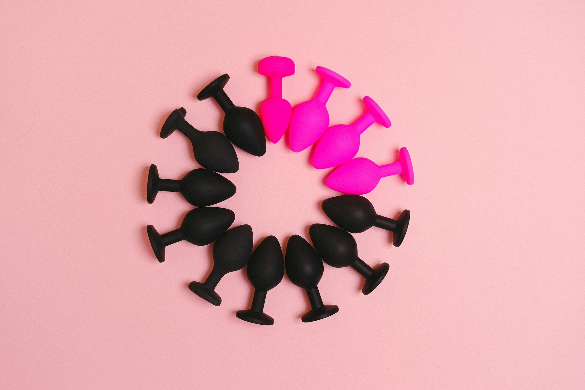 Colorful silicone plugs arranged in a circle on a pink surface, offering a stylish presentation.
