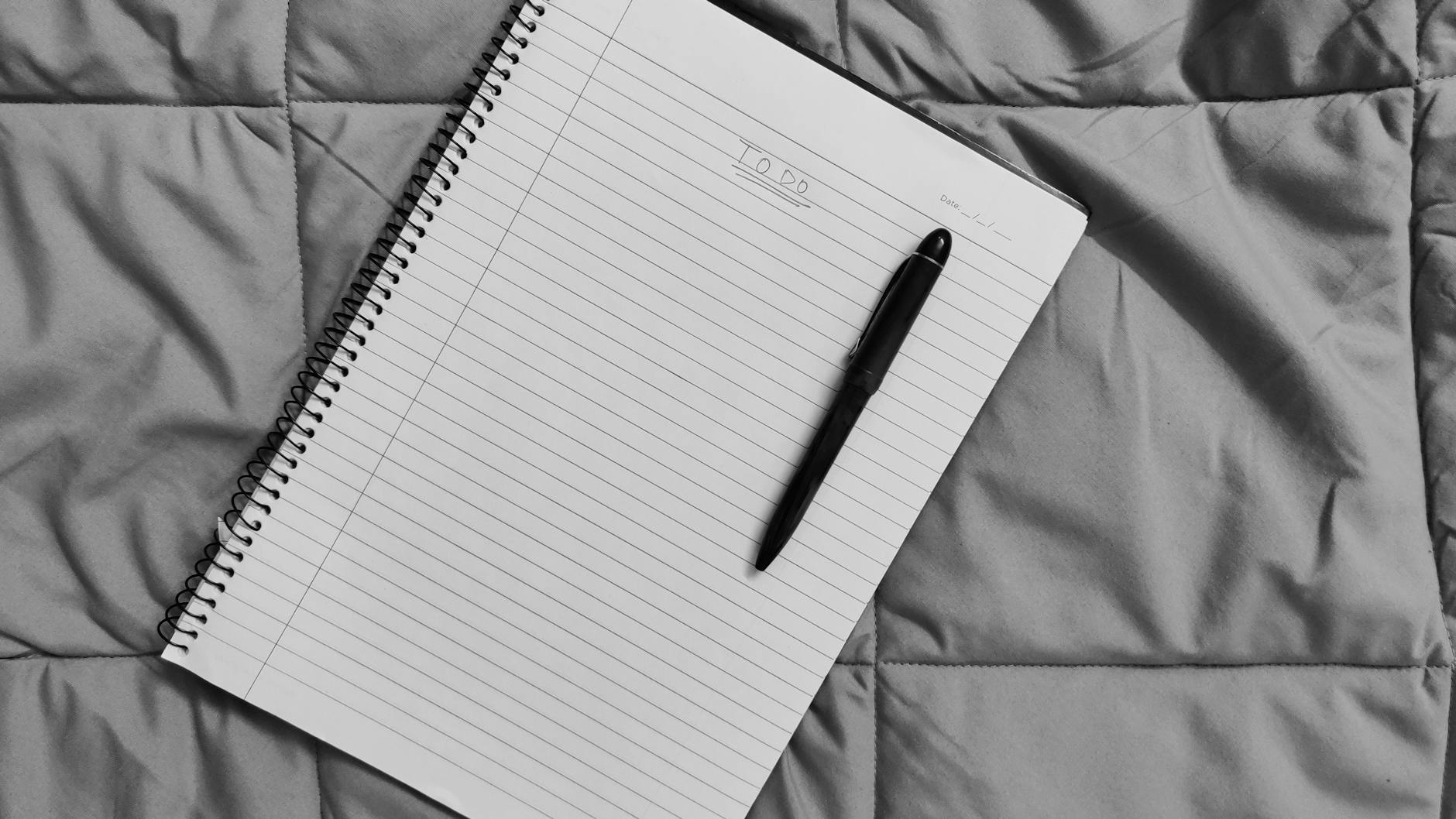 A minimalist to-do list on a spiral notebook with a black pen, perfect for planning and organization.