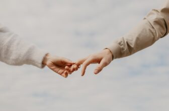 person in white long sleeve shirt holding hands with woman in white long sleeve shirt during