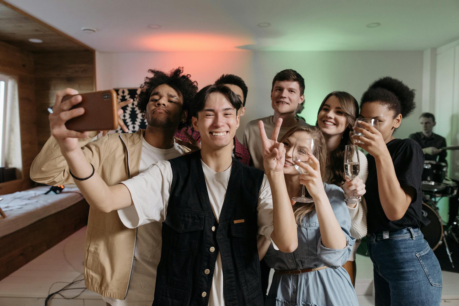 A diverse group of friends taking a selfie while enjoying a fun indoor party celebration