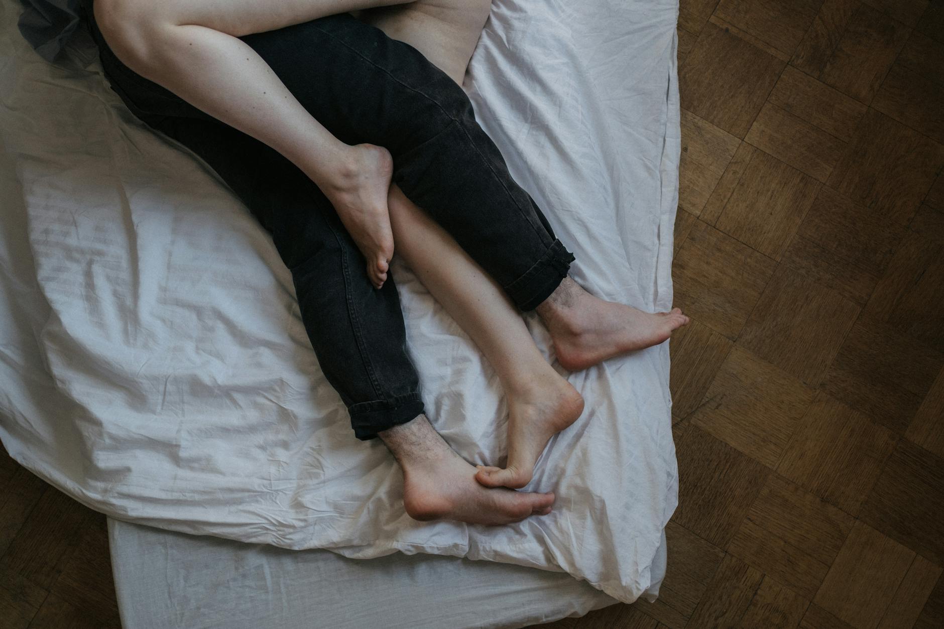 An intimate scene of a couple relaxing barefoot in a cozy bedroom, emphasizing love and togetherness