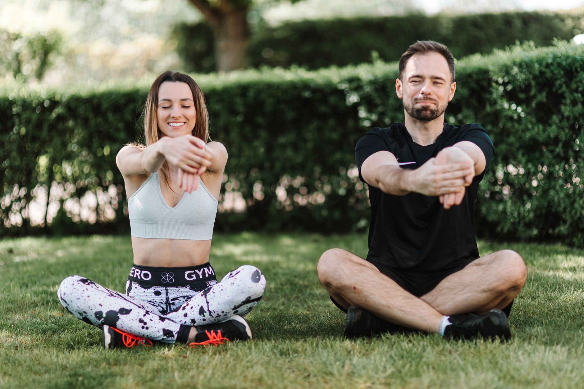 A couple enjoying a relaxing stretch outdoors, promoting fitness and wellness