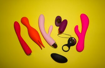 Studio setup showcasing colorful sex toys on a bright yellow background, featuring various shapes and designs