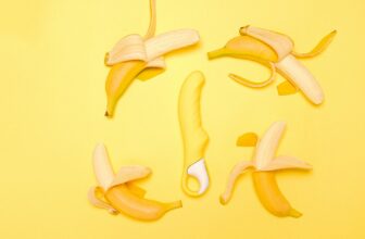 Creative flat lay of a yellow silicone vibrator surrounded by peeled bananas on a yellow background