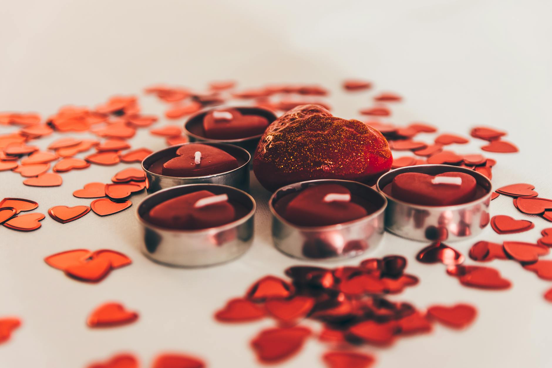 Heart-shaped red candles surrounded by decorative hearts, perfect for Valentine's Day celebrations