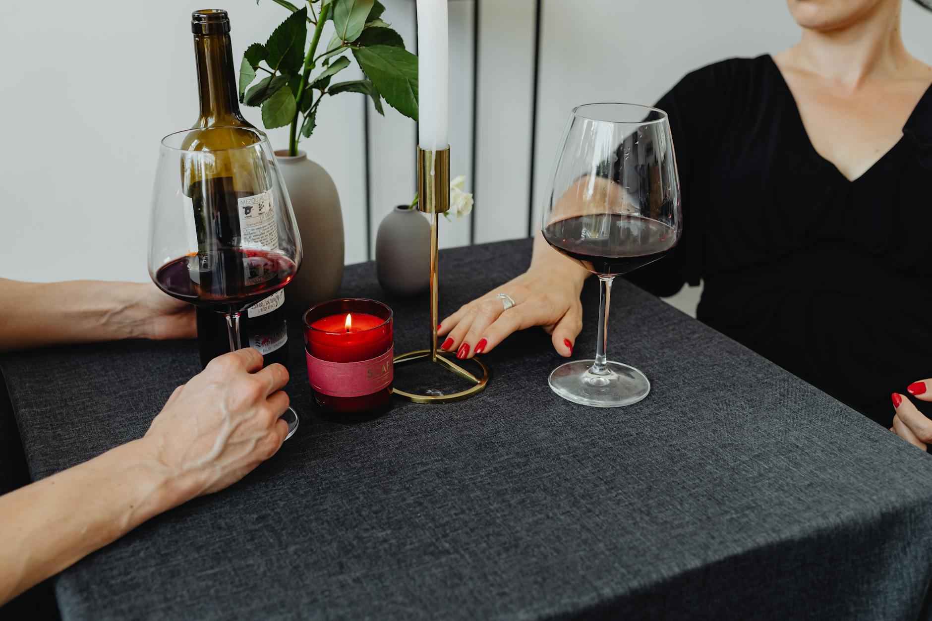 Intimate dinner with red wine and candles, perfect for a romantic evening